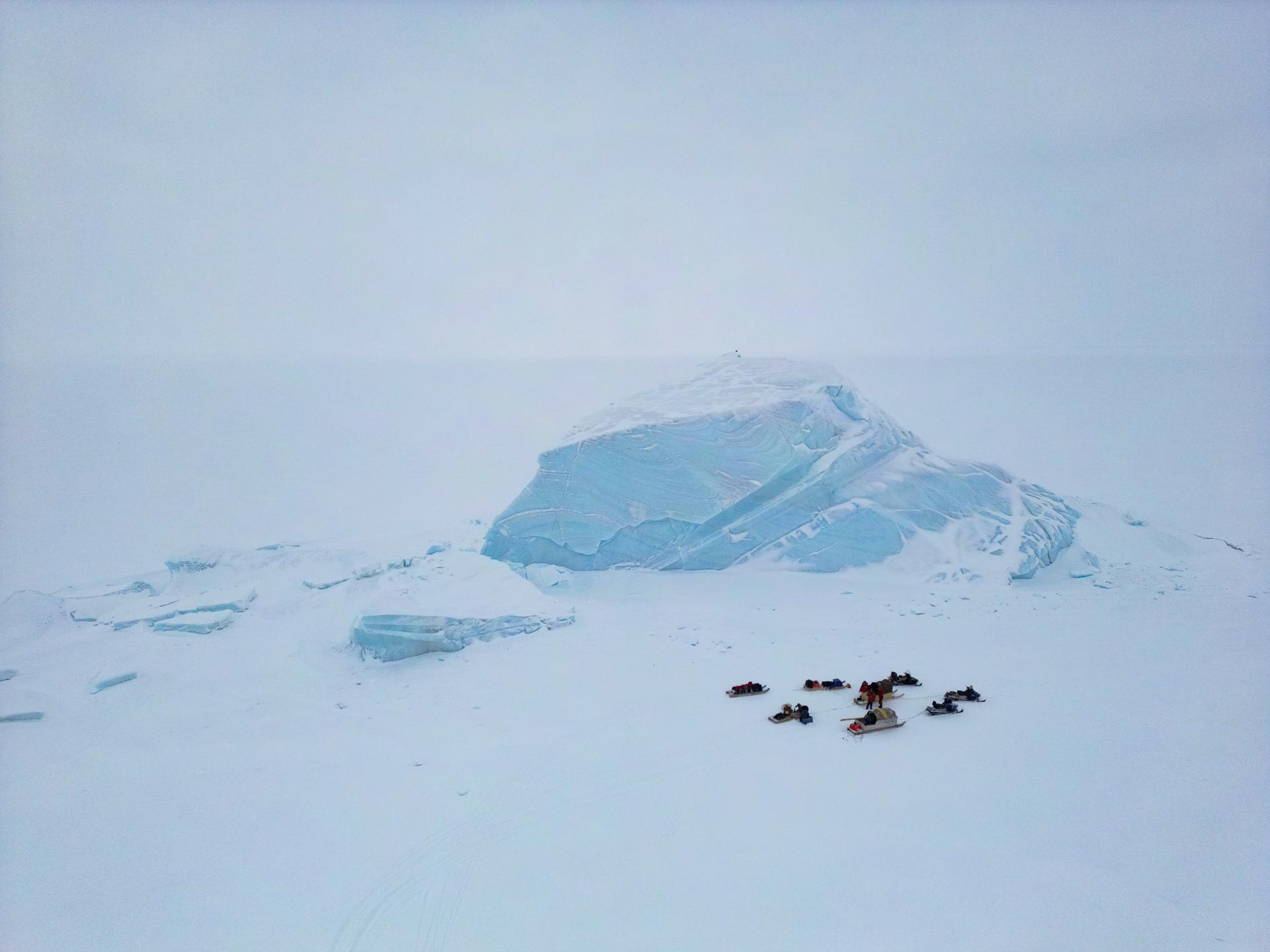 Arctic expedition beside a blue iceberg on Ellesmere Island